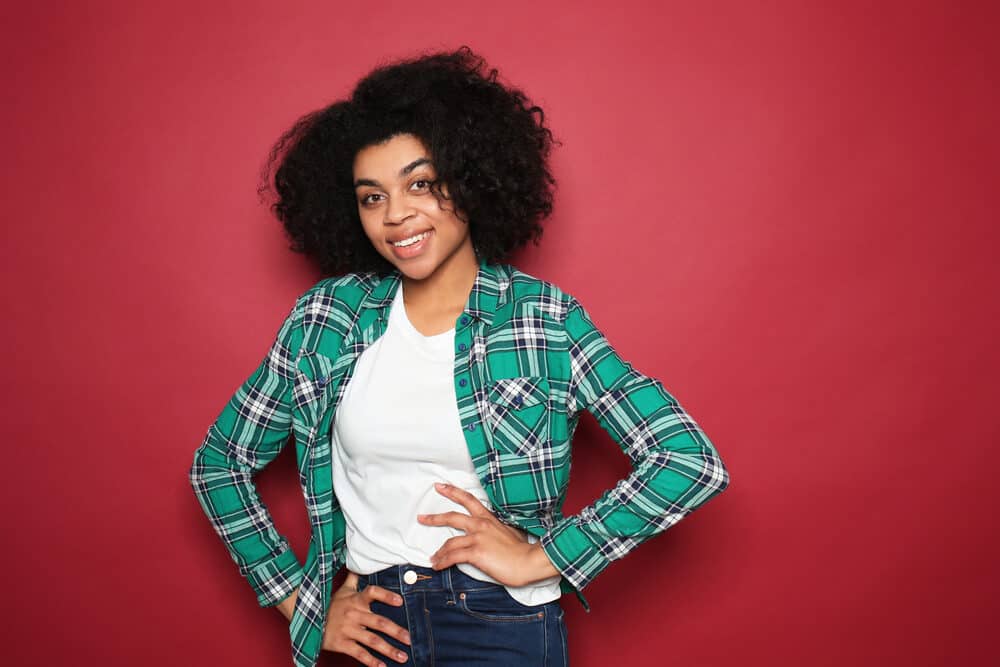 Black lady with 4A natural hair colored with henna dye wearing a green, white, and black flannel shirt.