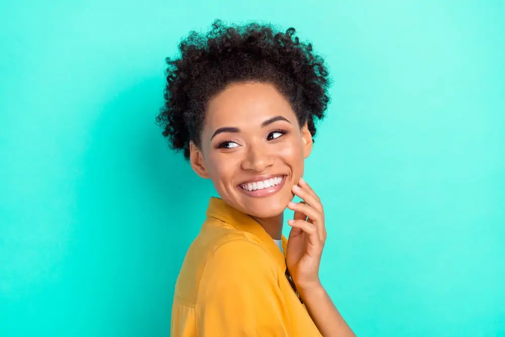 When Is the Best Time to Take Biotin Vitamins, Gummies, or Pills? 4 Black lady with fluffy 3B curls a ingest biotin tablet daily before getting the morning started.