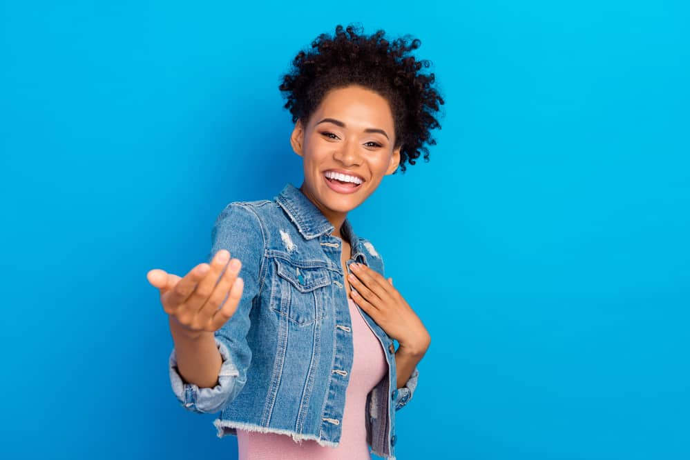 Very attractive black girl with healthy hair wearing natural make-up and permanent dye in her natural curls.