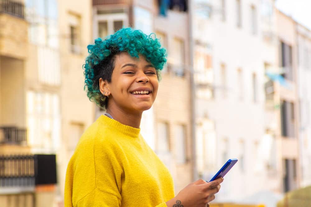 Young girl leaving a professional hair stylist with a blue hair color after semi-permanent dye treatment.