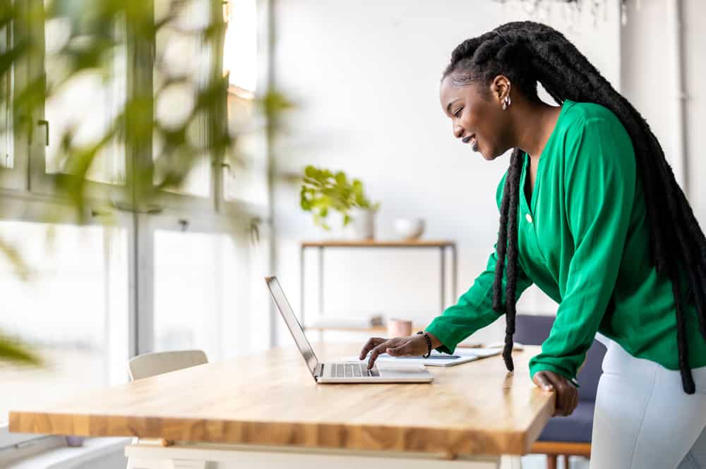 A woman wearing a green casual shirt and jeans reading about how to keep her hair healthy.