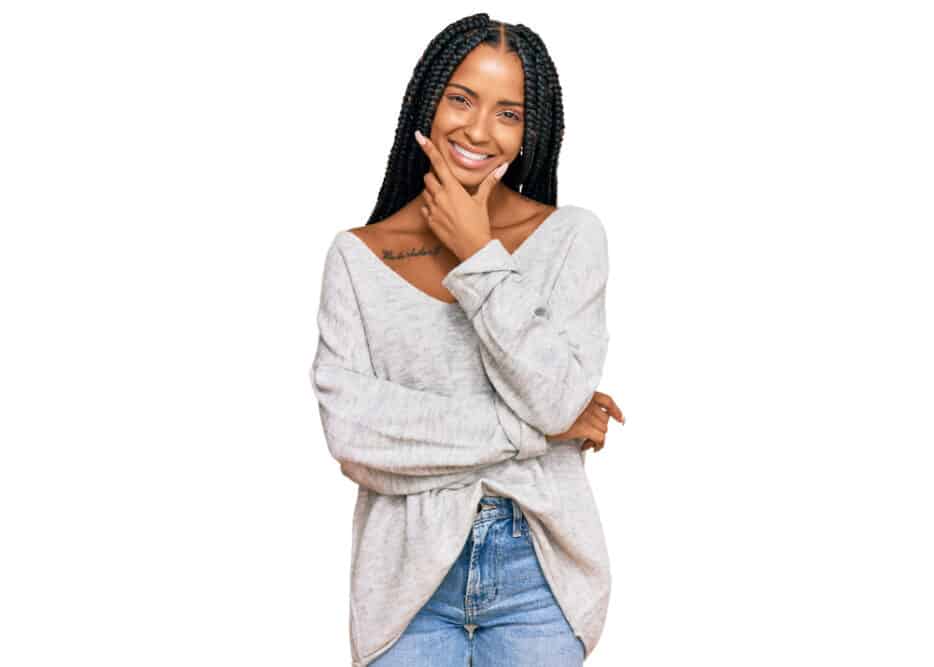 A beautiful Hispanic woman wearing braided hair across her entire head with a beige sweater.