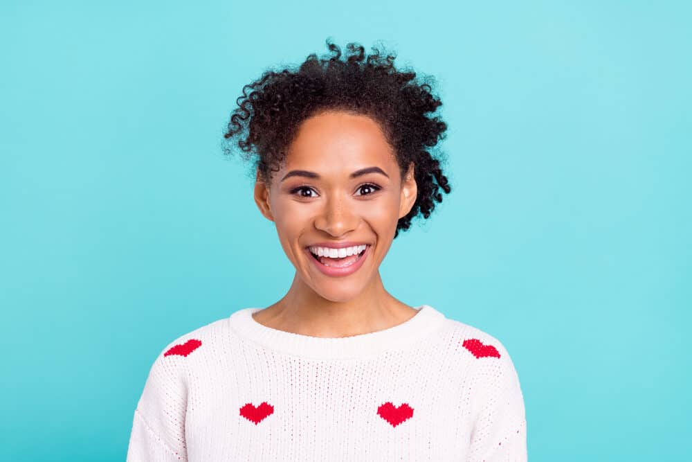 African American female wearing permanent hair dye on dark brown natural hair with pink lipstick.