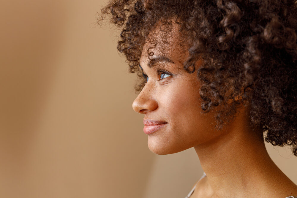 Charming female with thicker hair follicles styled with volumizing hair powder that has a baby powder texture.