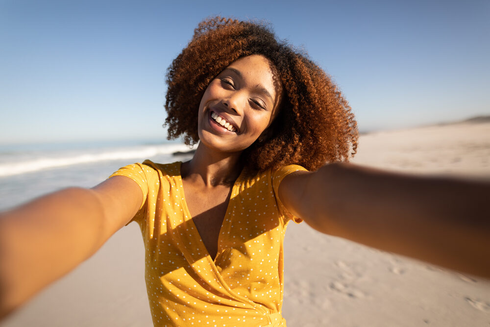 Black girl with dyed natural hair extensions with edges styled with hair gel.