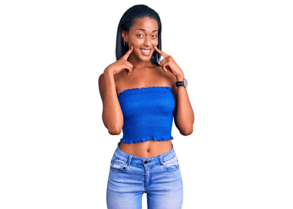 Cute black lady with light brown skin and healthier hair wearing a casual blue t-shirt and hoop earrings.