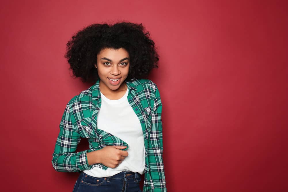 A flirty black woman after completing the hair dyeing process with stale henna powder from the henna plant.