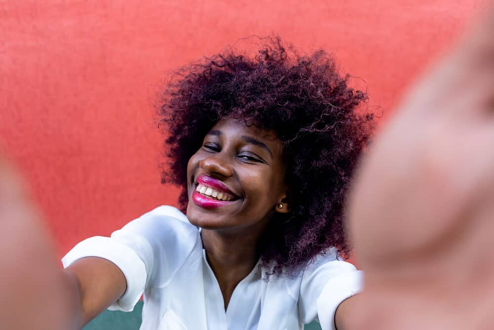 African American taking a selfie following a salon color appointment where she dyed her hair "dirty" as a case study.