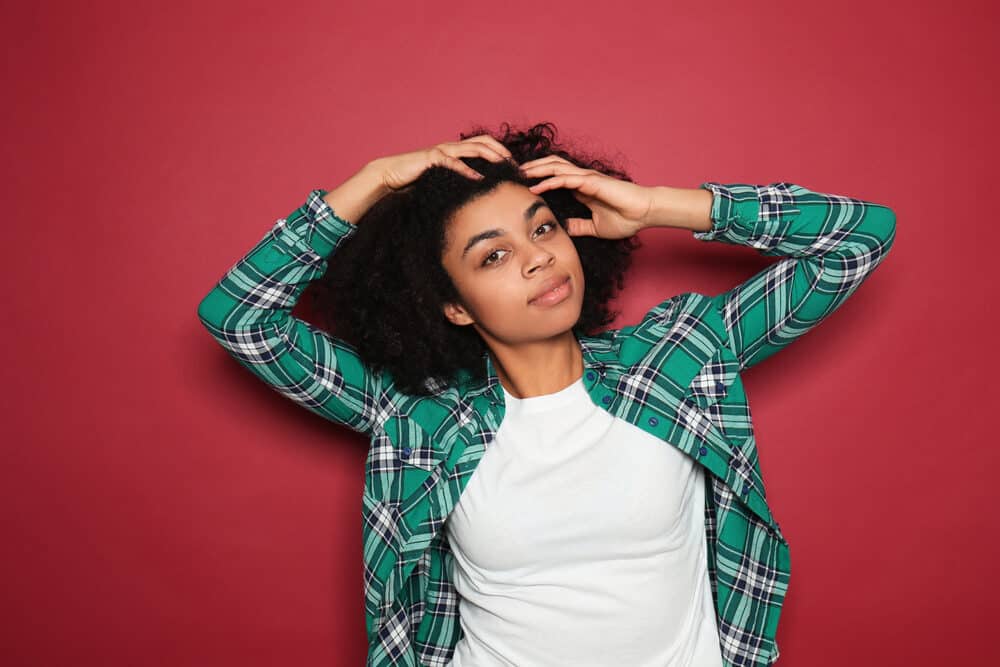 Adult female with a twist-out hairdo styled with olive oil and lemon juice on 4A curls that are a rich brown color.