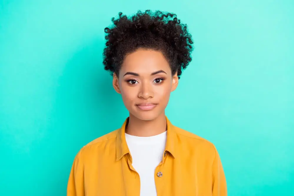 When Is the Best Time to Take Biotin Vitamins, Gummies, or Pills? 6 A cute African American woman with beautiful skin takes a daily skin vitamin due to its repairing and restorative process.