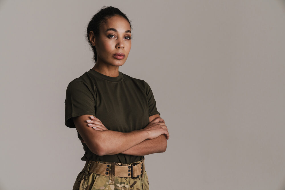 African American U.S. Army officer wearing standard camouflage pants and a green shirt.