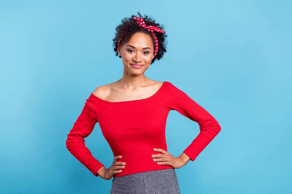 An African American female with curly and dry hair after using the squish to condish method to wash hair.