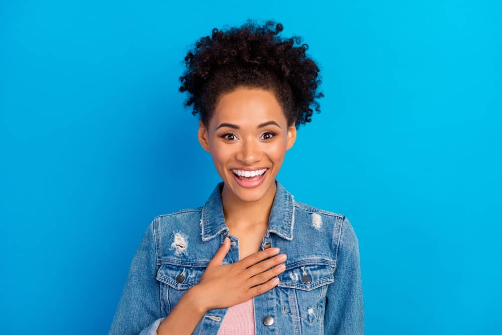 A woman with curly hair wearing subtle make-up highlighting her beautiful natural shade.