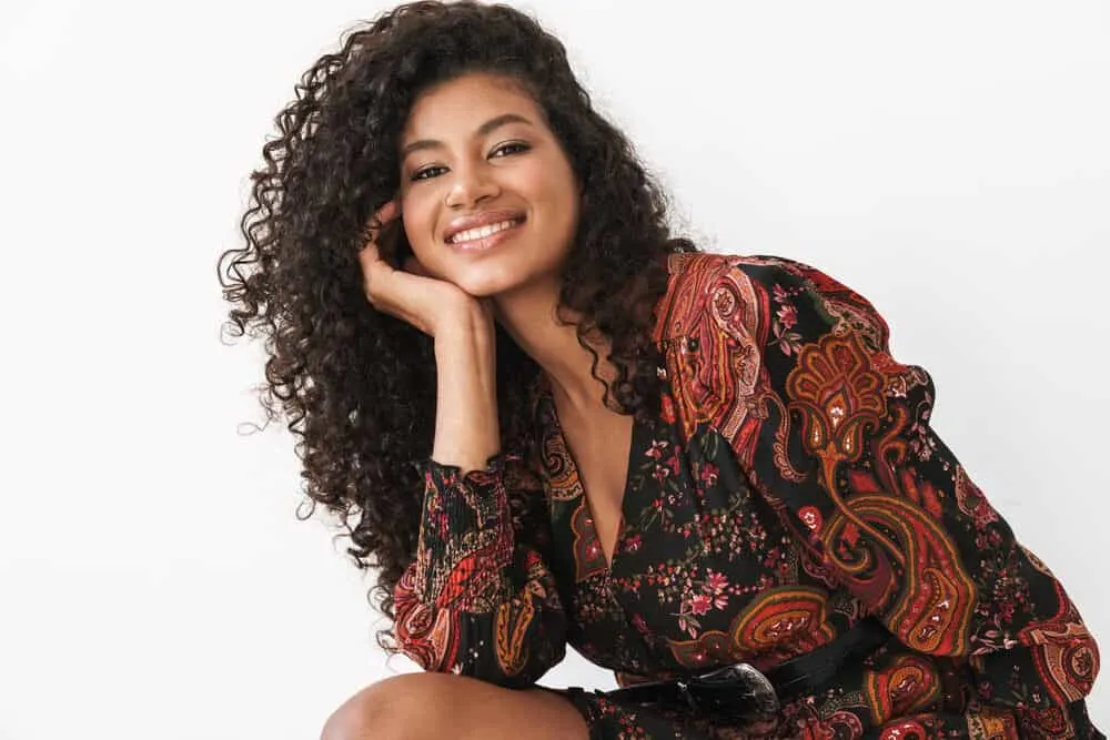 How To Get Rid of Tension Bumps on Scalp: Will They Go Away? 4 Adult female wearing a casual dress and hair extensions on her 3A natural curls.