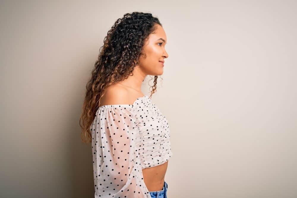 Mixed race woman with a professional cut on long hair wearing a polka dot casual shirt.