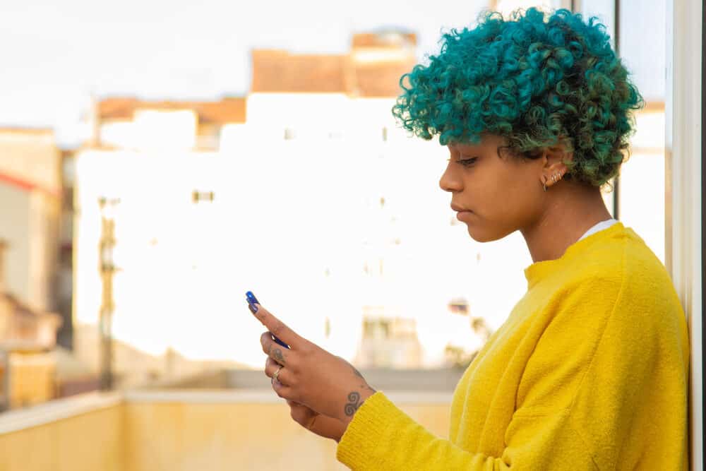 African American female with two-toned curls with a blue tint in the front yellowish blue color in the back.