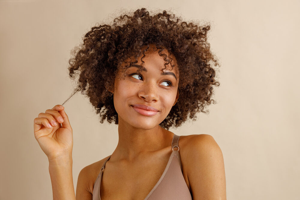 Cute multiracial woman with thin hair strands styled with volumizing powder.