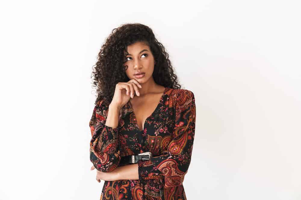 Attractive African woman with brown natural hair looking into the sky with a curious look on her face.