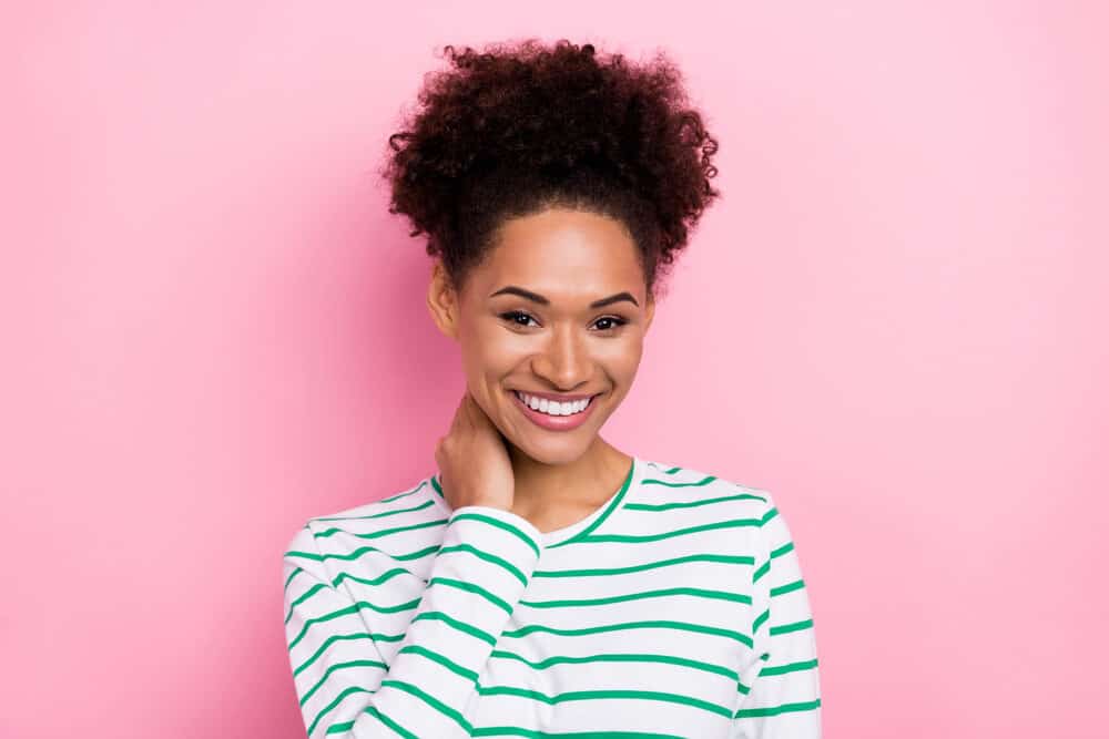 African American female wearing temporary dye on 4A natural curls with a white and green sweater.