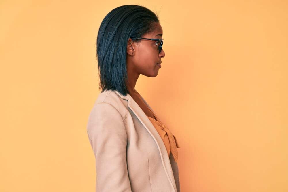 Beautiful African American female with healthy hair after getting Dominican Blowout and flat ironing her natural curls.