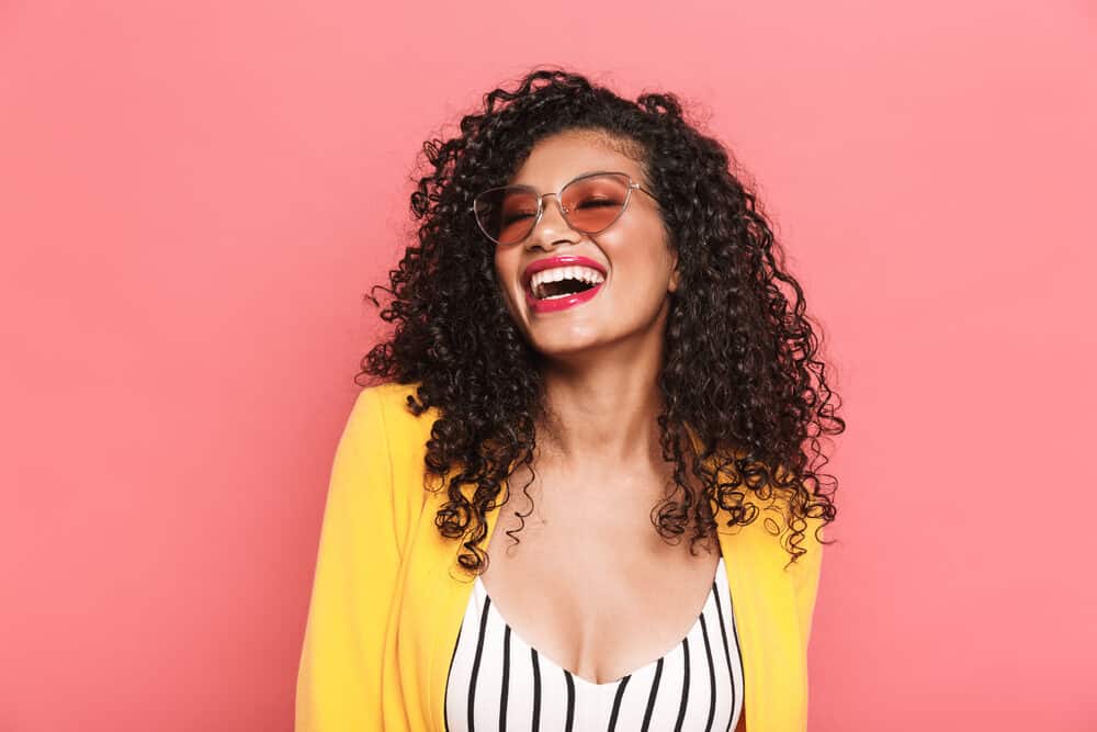A fun young African lady with curly and wavy hair wearing a business casual outfit perfect for the work environment. 