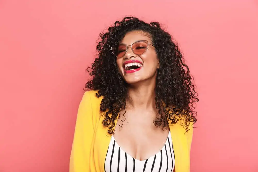Is Curly Hair Attractive? Why? What Do Guys Think? 3 A fun young African lady with curly and wavy hair wearing a business casual outfit perfect for the work environment.