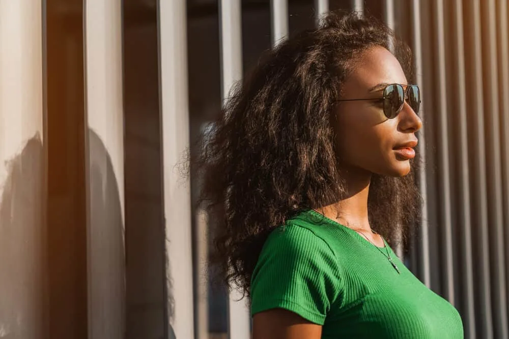 Does Straightening Curly Hair Damage It? Ruin It Forever? 2 Stunning African American woman with straight hair wearing a gold necklace and black sunglasses.