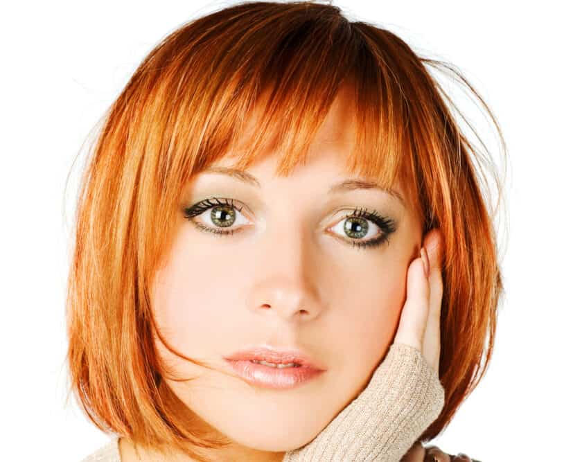 Curious Caucasian female with dyed hair wondering, "Why did her hair turn orange and brassy after hair coloring".