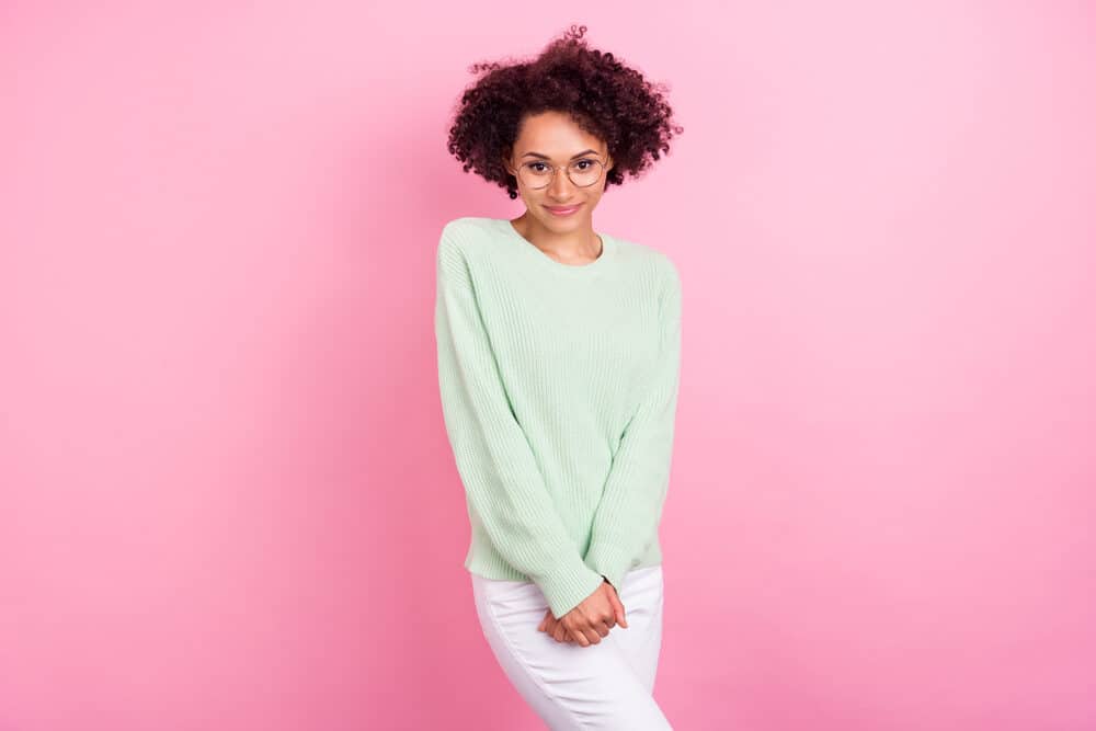 Charming black woman wearing a wash n go hairdo styled with essential hair oils.