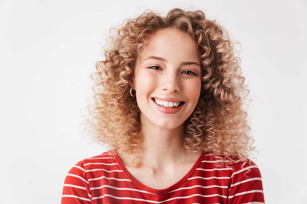 A woman with tighter curls after using heat styling tools to create more defined curls and loose waves.