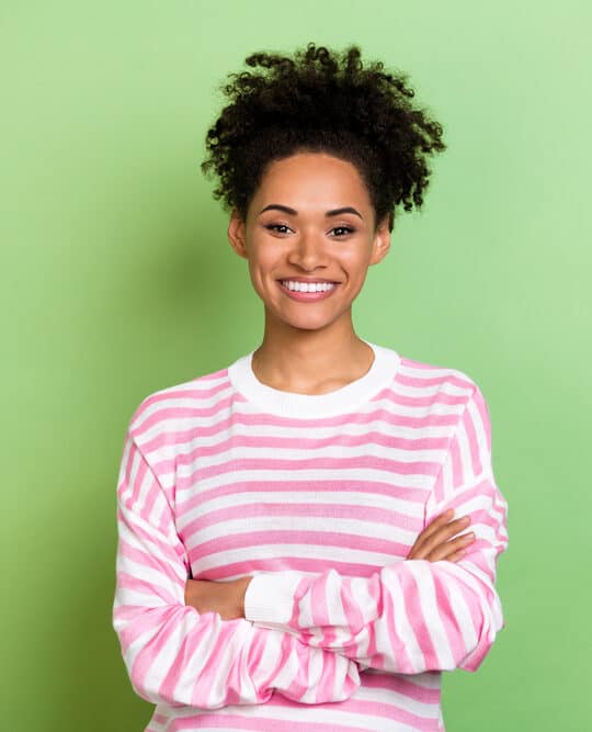 Cute African American female with color-treated hair follicles on 3C healthy hair after a salon treatment.