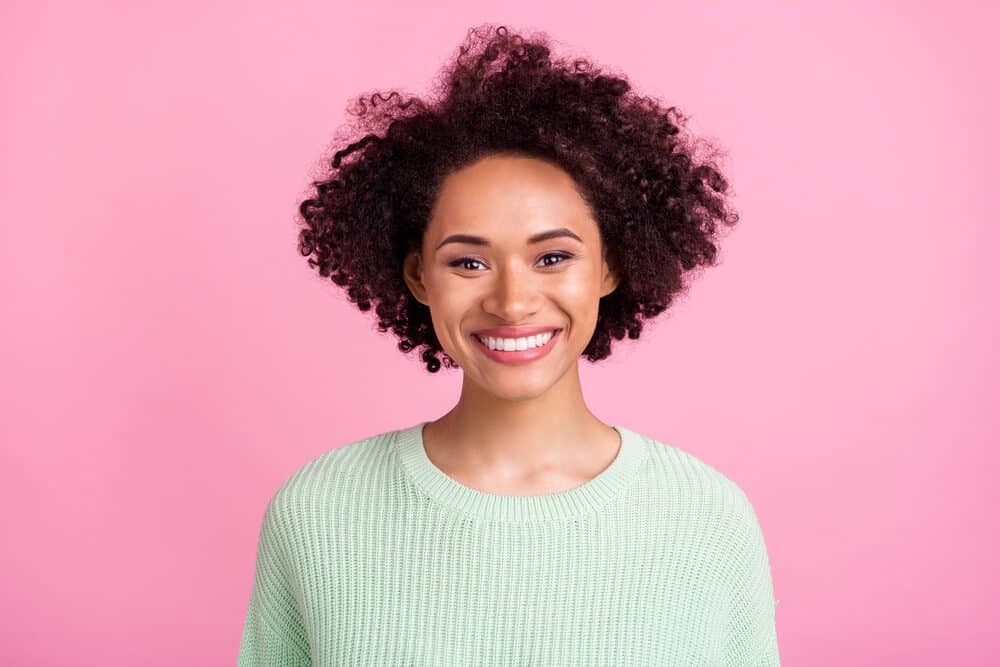 Black lady with 3C curls takes biotin, amino acids, and other dietary supplements to encourage hair health.