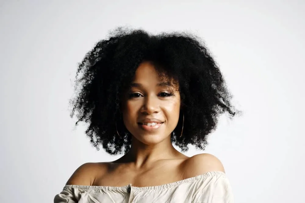 Does Vegamour Work for Hair Loss? Thinning Hair? Alopecia? 6 Lady with glowing yellow skin wearing a twist-out hairstyle on her thinning hair follicles.