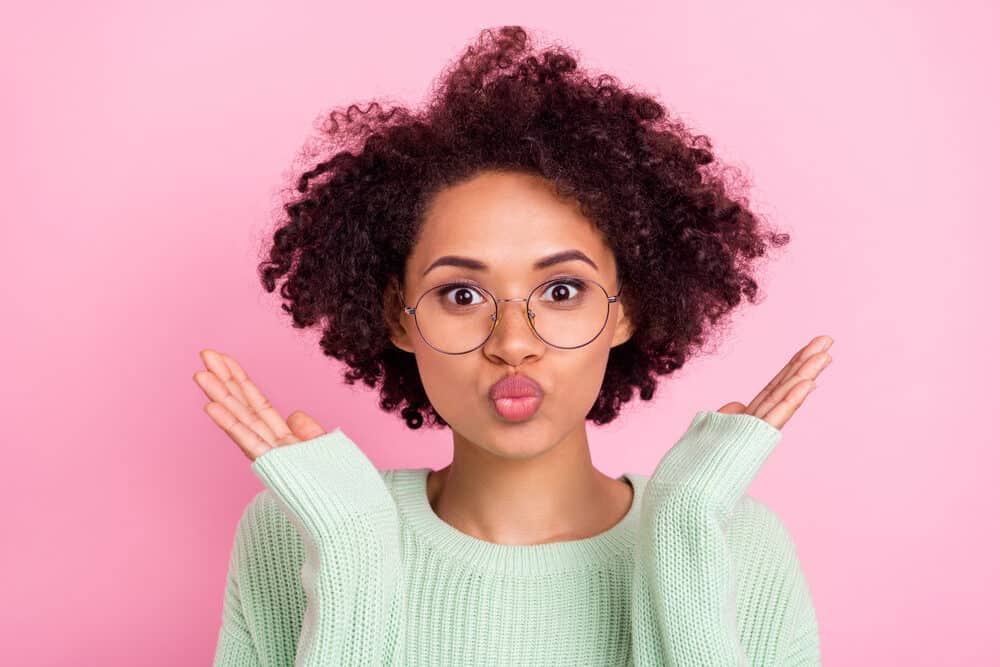 Adorable light skin female wearing round eyeglasses, pink lipstick, and casual green sweater.