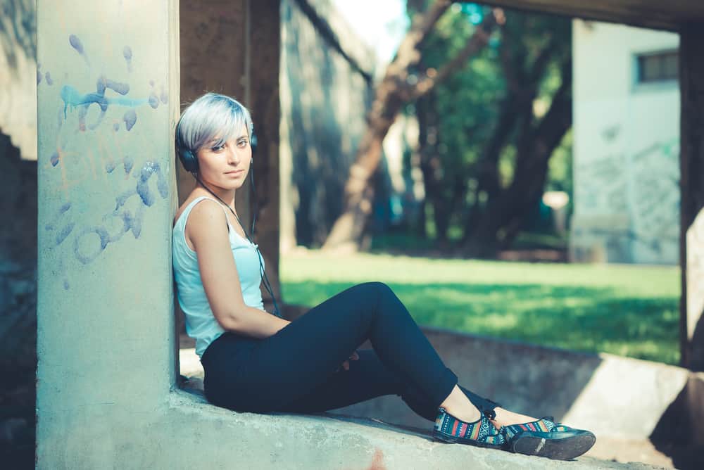 Beautiful Caucasian female with blue hair wearing casual clothes with colorful shoes.