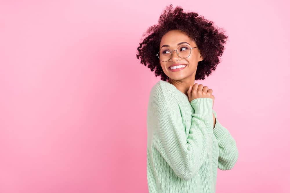 Lady with bouncy curls takes a water-soluble vitamin to encourage healthy hair, skin, and nails.