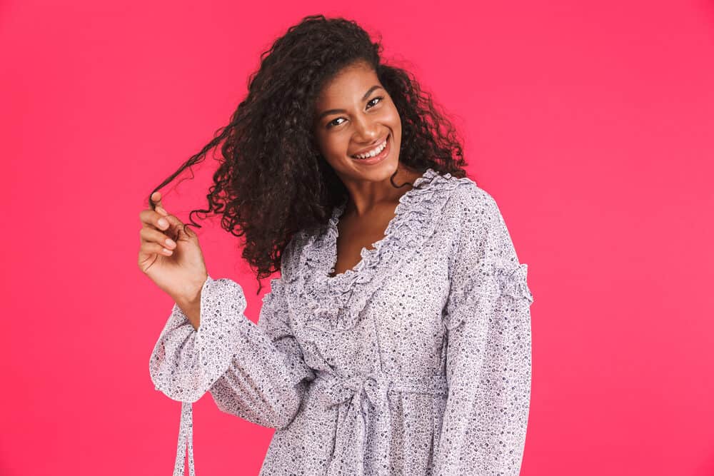 Young African American woman with thick hair and bouncy curls created with a Dyson Airwrap hair styling tool.