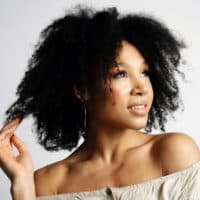 African American female with noticeably denser hair strands is concerned about hormone-related hair loss.