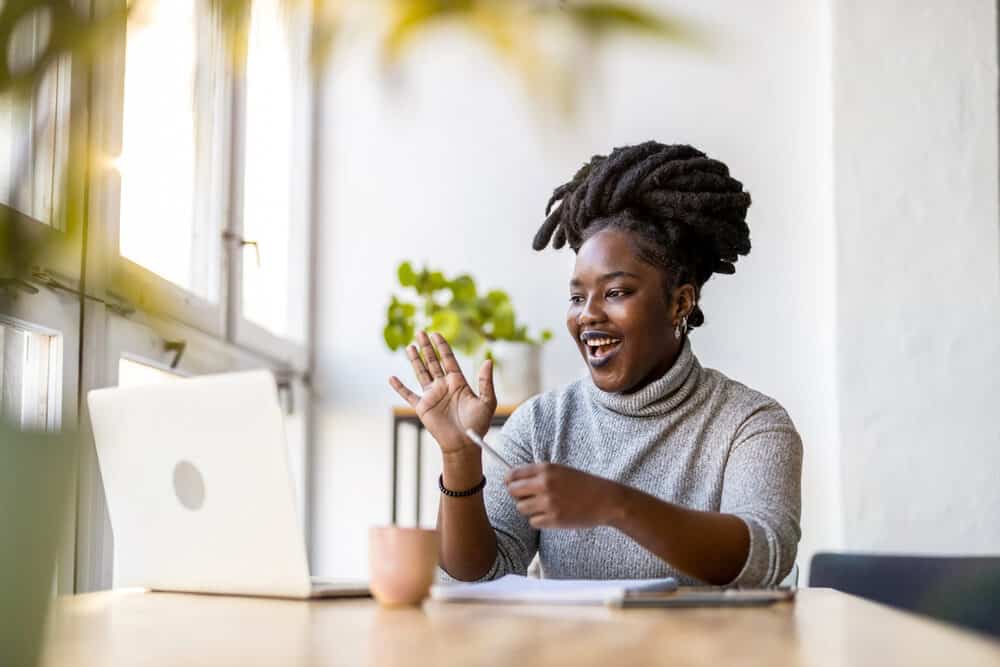 Cute African American lady wearing freeform dreads on top of her head in pineapple updo.