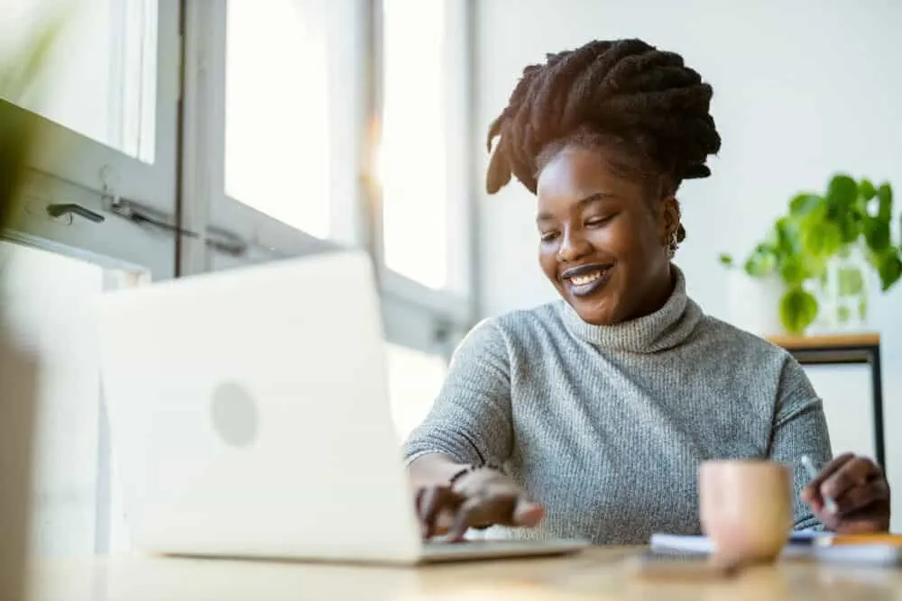 How to Get Congo Dreads: Freeform, Crochet, Interlock, and More 3 Black girl writing a research paper on Bob Marley and the actual timeline that he started to fully grow freeform locs.