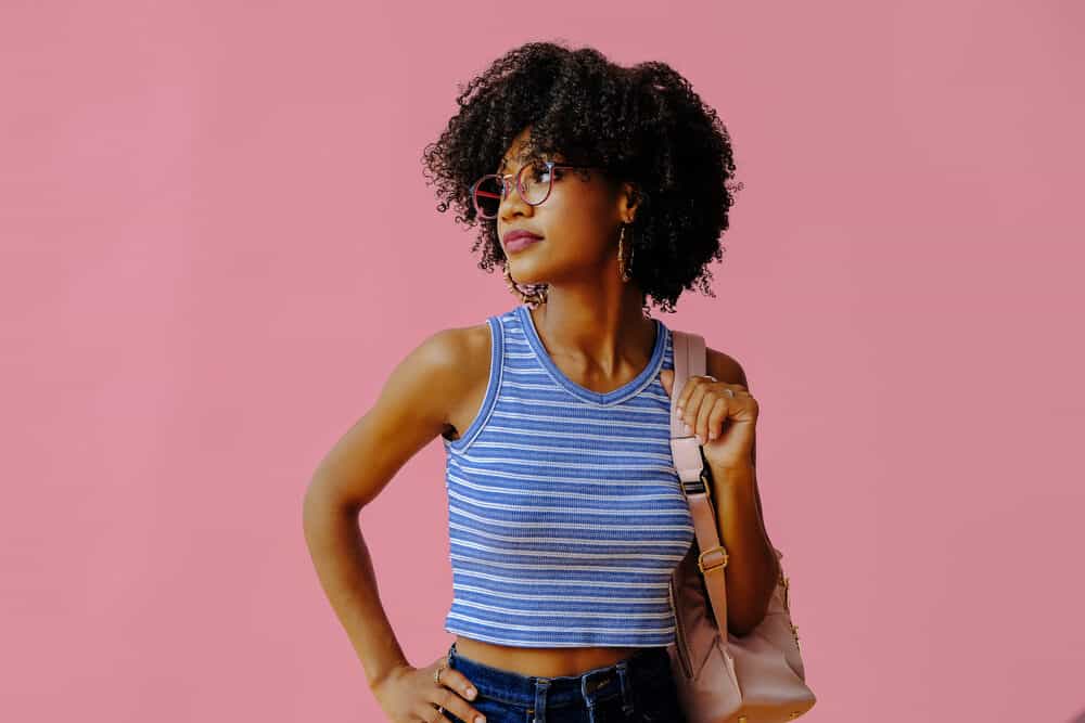 African American woman with light brown, caramel skin wearing naturally kinky hair follicles.