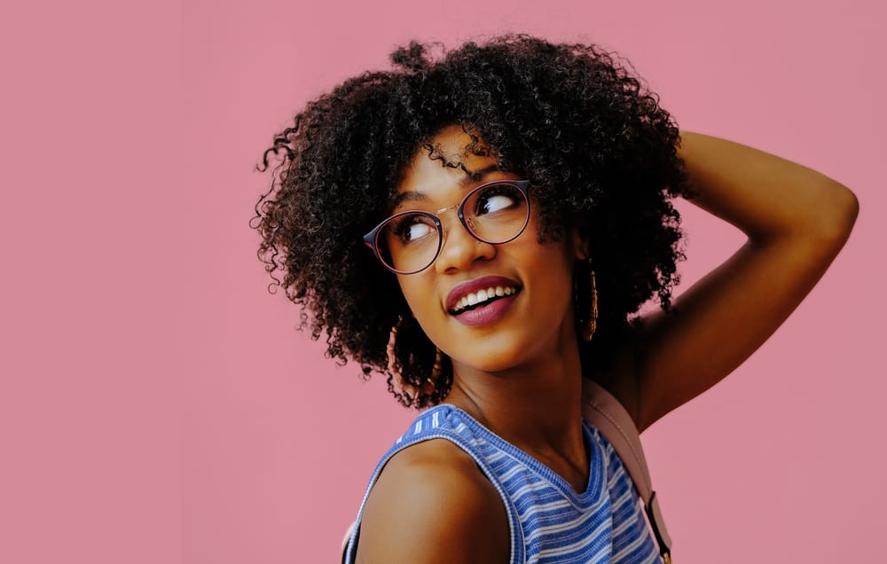 Black lady with 4A curly hair follicles with medium hair thickness on very long hair wearing a blue shirt.