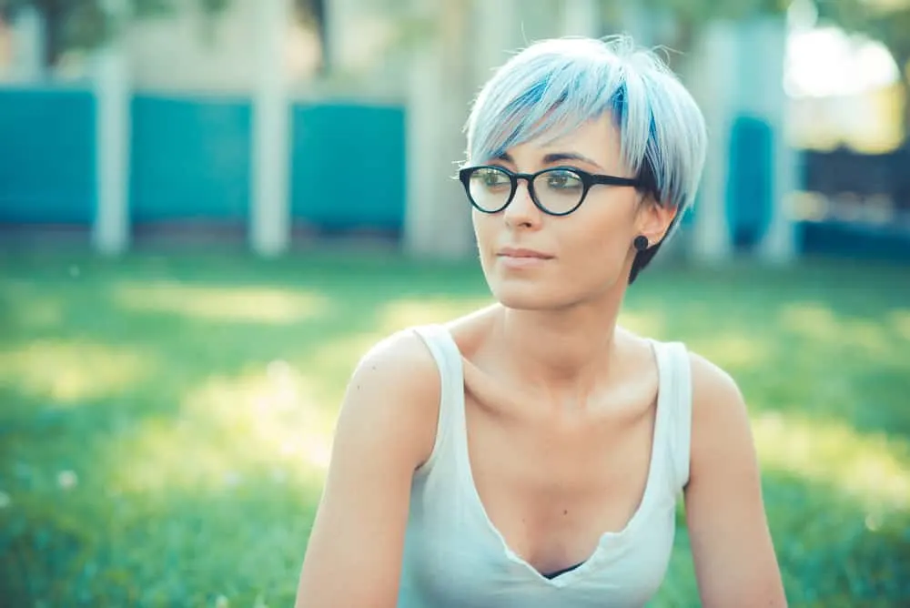 What Color Cancels Out Blue Hair? Best Color to Dye Over Blue Hair 3 Young female with 1C hair colored with blue hair dye wearing black glasses and a white tank top.