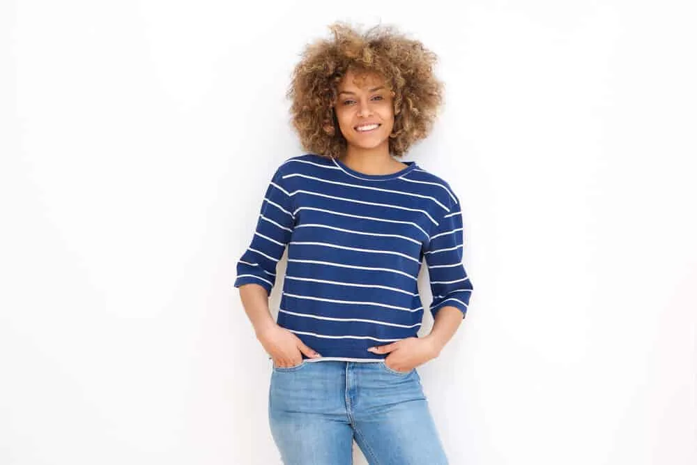 What Does Clarifying Shampoo Do to Colored Hair? Lighten? 3 African American female with subtle highlights after washing her curls with a DIY baking soda rinse.