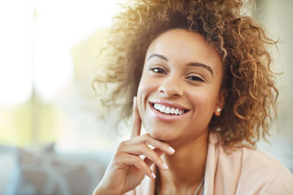 Cute African American female with medium brown hair after using a high-lift hair color treatment on her 4A curls.