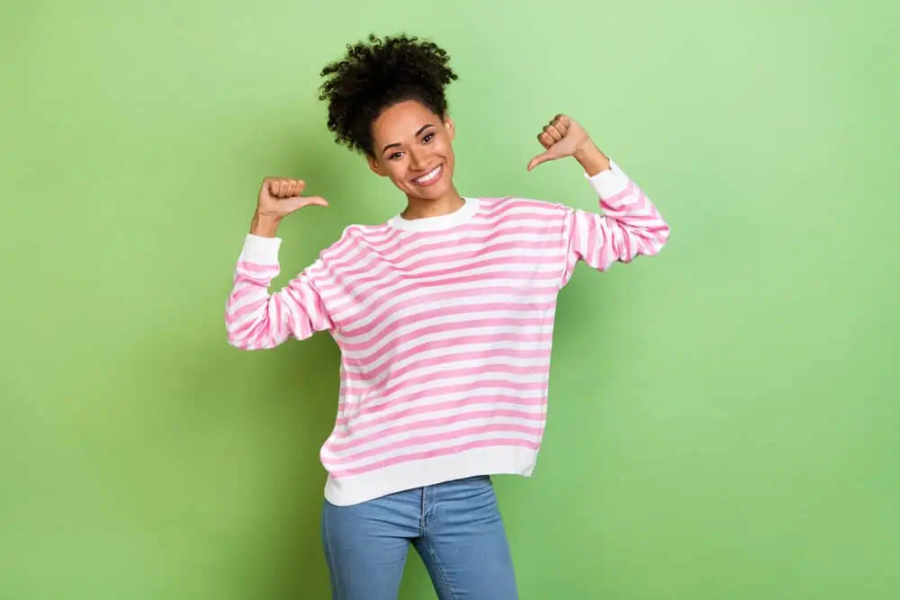 Can You Leave Olaplex 3 on Overnight or Leave It on Too Long? 7 A black lady with natural curls dressed in a pink shirt after using an Olaplex treatment to keep her hair healthy.