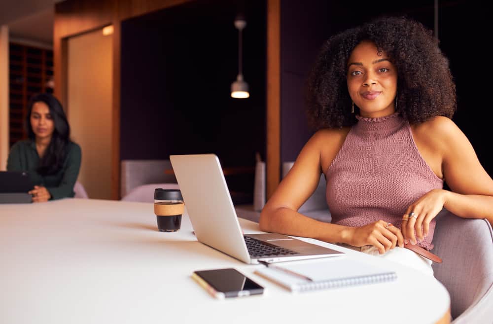 Black girl wearing platinum blonde earrings while researching which hair colour fades faster than other hair dyes.