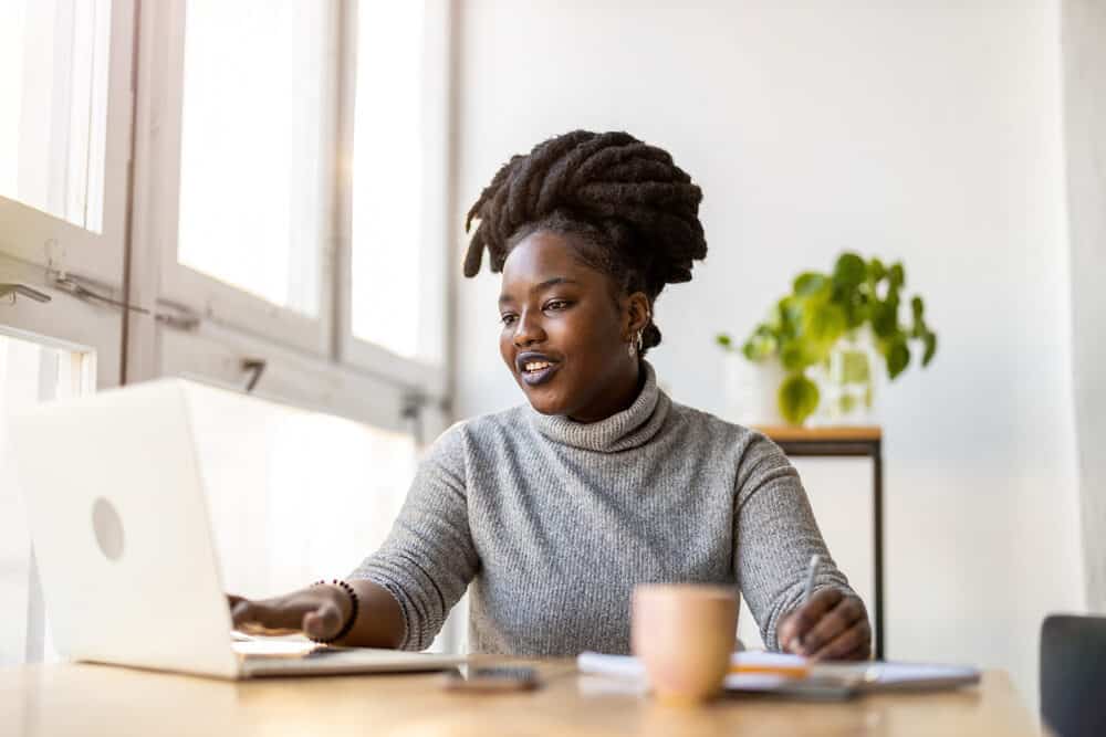 Adult female with freeform dreads on a 4C hair type writing an article on why everyone's hair type is different.