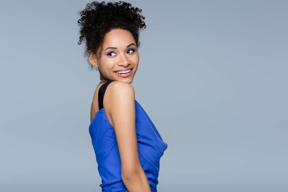 A beautiful African American female wearing a pineapple updo secured with hair clips during the hot summer season.