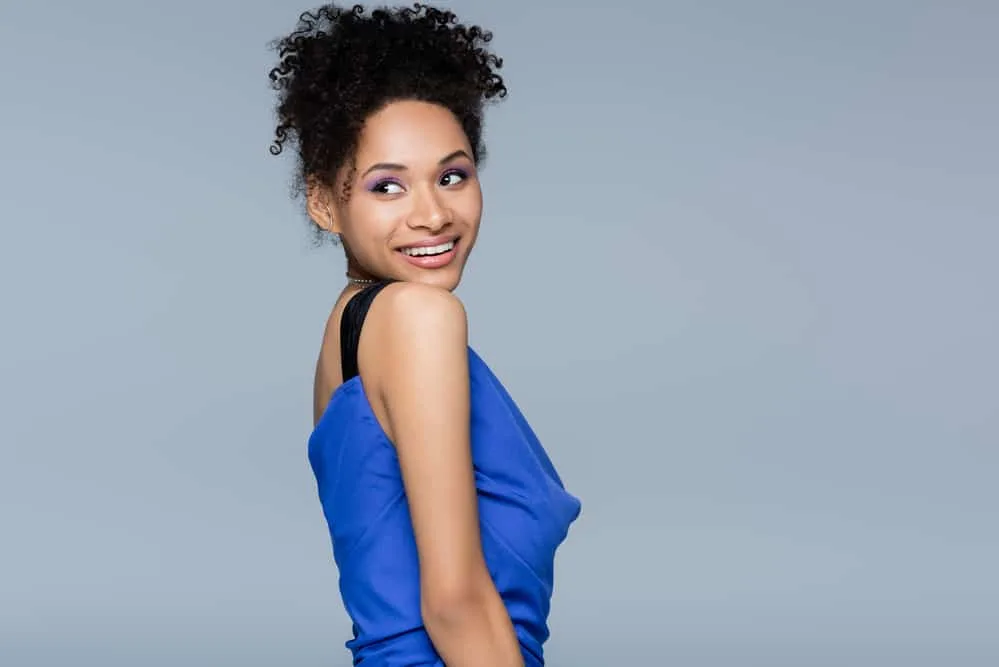 Should You Do Hair or Makeup First When Getting Ready? 1 A beautiful African American female wearing a pineapple updo secured with hair clips during the hot summer season.